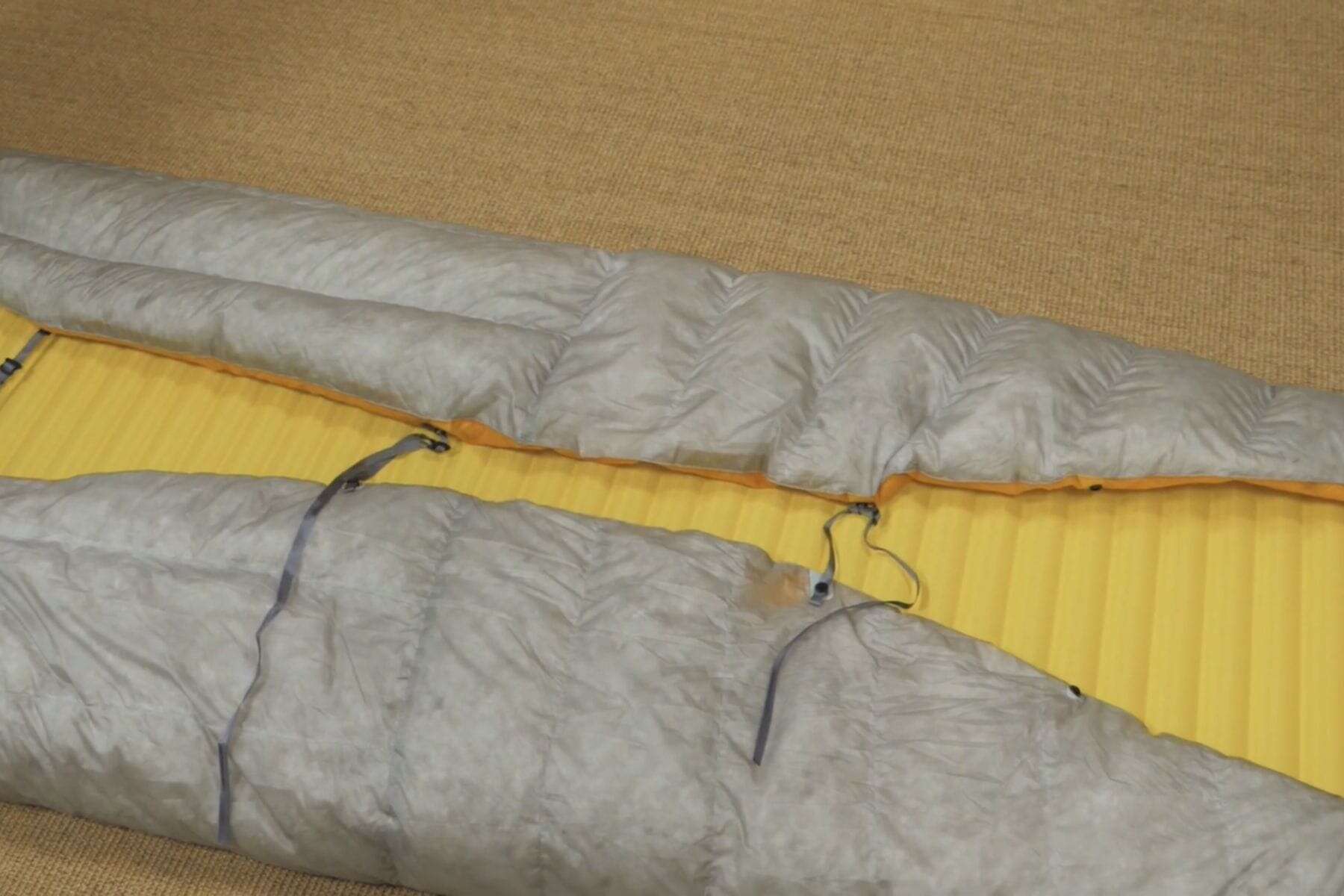 QuiltLock allows you to strap your quilt to a sleeping pad. 